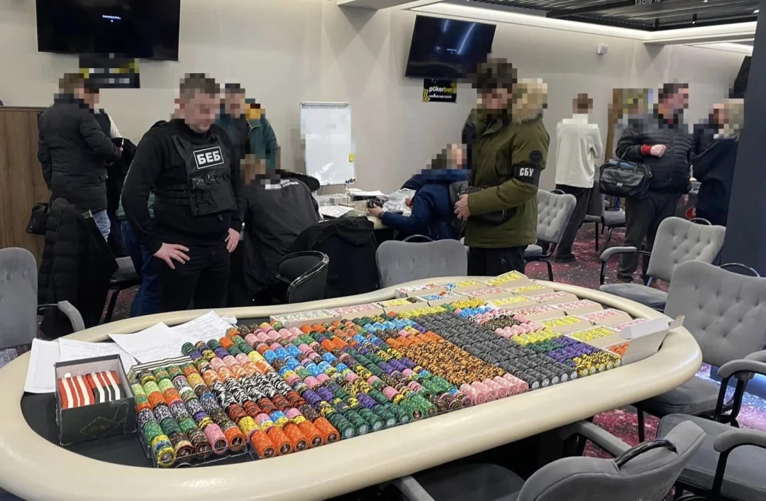 Співробітники БЕБ під час обшуку нелегального покер-клубу з фішками на столі