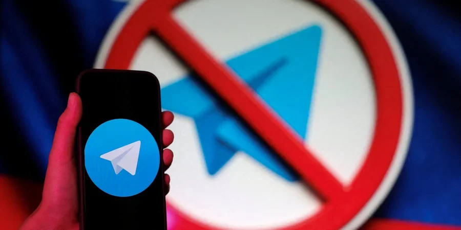 Смартфон з Telegram на тлі логотипу месенджера під знаком заборони t.me