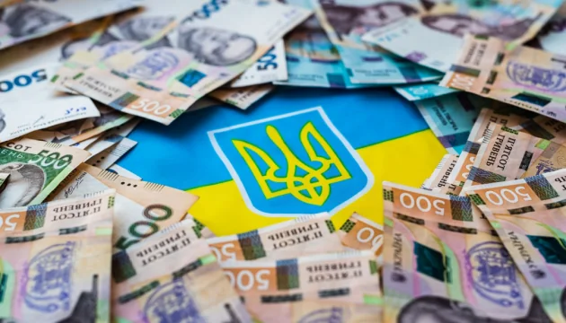 Украинские гривны и флаг на фоне поступлений 3,4 млрд грн в бюджет