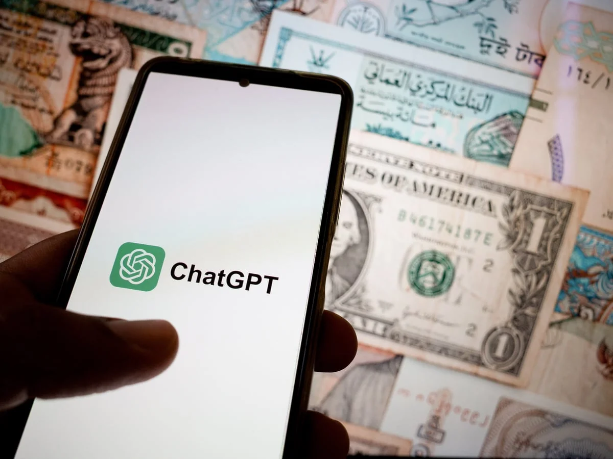 Смартфон з ChatGPT на тлі банкнот як символ ШІ у фінтеху