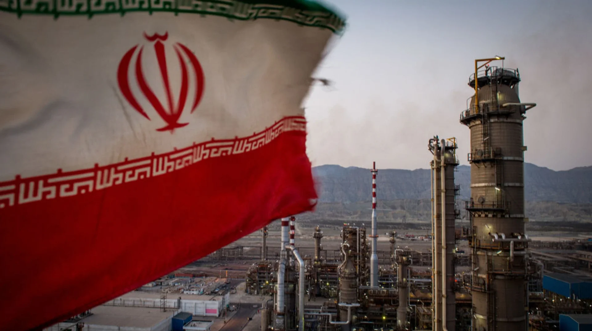 Флаг Ирана на фоне нефтеперерабатывающего завода вопреки санкциям США