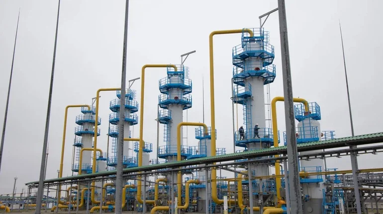 Газовый комплекс с белыми башнями, синими платформами и жёлтыми трубами