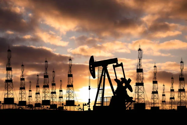 Нефтяные качалки в силуэте на закате солнца после скачка цен на нефть Brent