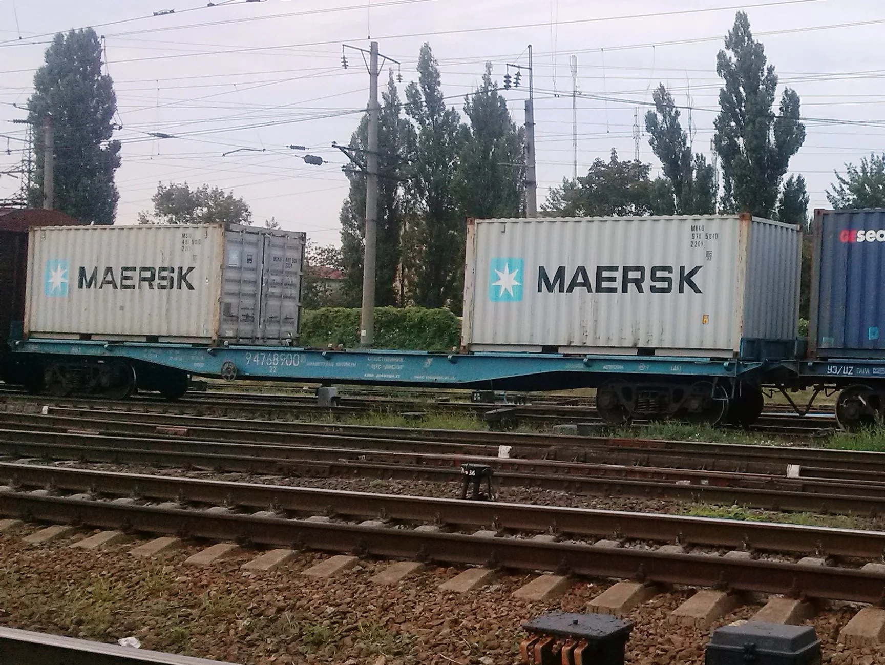 Два контейнери Maersk на залізничній платформі серед колій